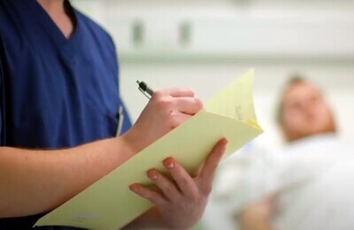 Кодирование от алкоголизма в клинике Врач в больничной палате делает запись